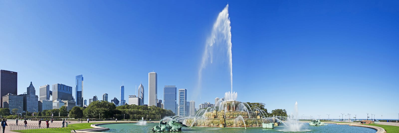 Buckingham Fountain in Chicago, with skyscrapers on a clear day and turquoise water featuring ornamental sea horses, showcases the vibrant urban landscape blending historical architecture and modern skyline. | Houfy — No Fees, Book Direct