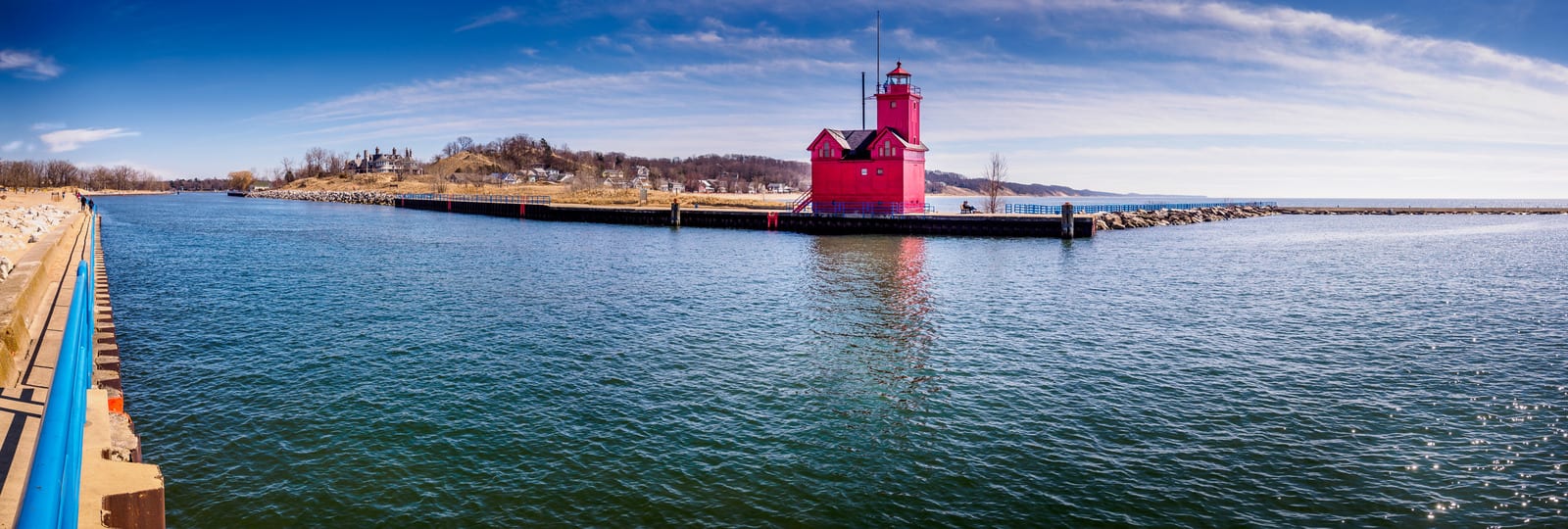 Holland Harbor Light, known as Big Red, stands strikingly against the blue waters of Lake Michigan in Holland, Michigan, with its vivid red color and picturesque shoreline, marking a perfect vacation spot. | Houfy — No Fees, Book Direct