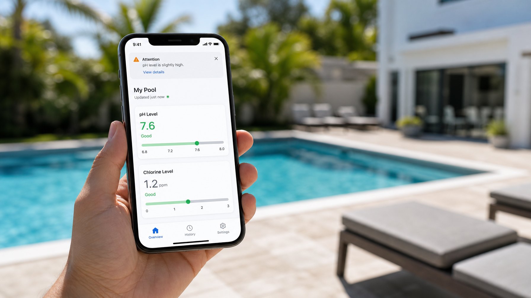 Hand holding a smartphone showing a pool monitoring app with pH and chlorine level indicators, with a vacation rental pool blurred in the background