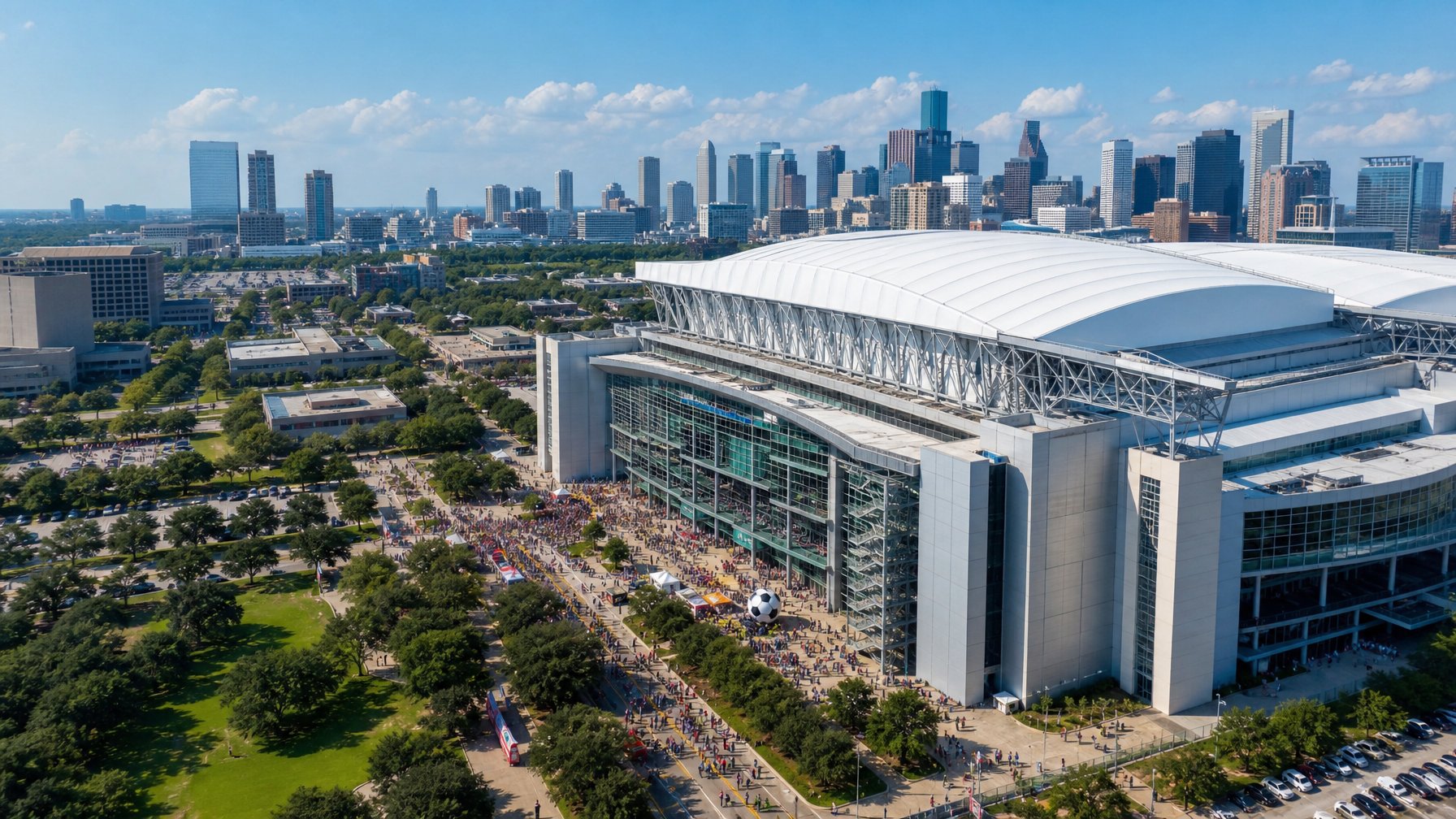 Fans gathering outside NRG Stadium in Houston next to a giant soccer ball sculpture with the Houston city skyline rising behind it