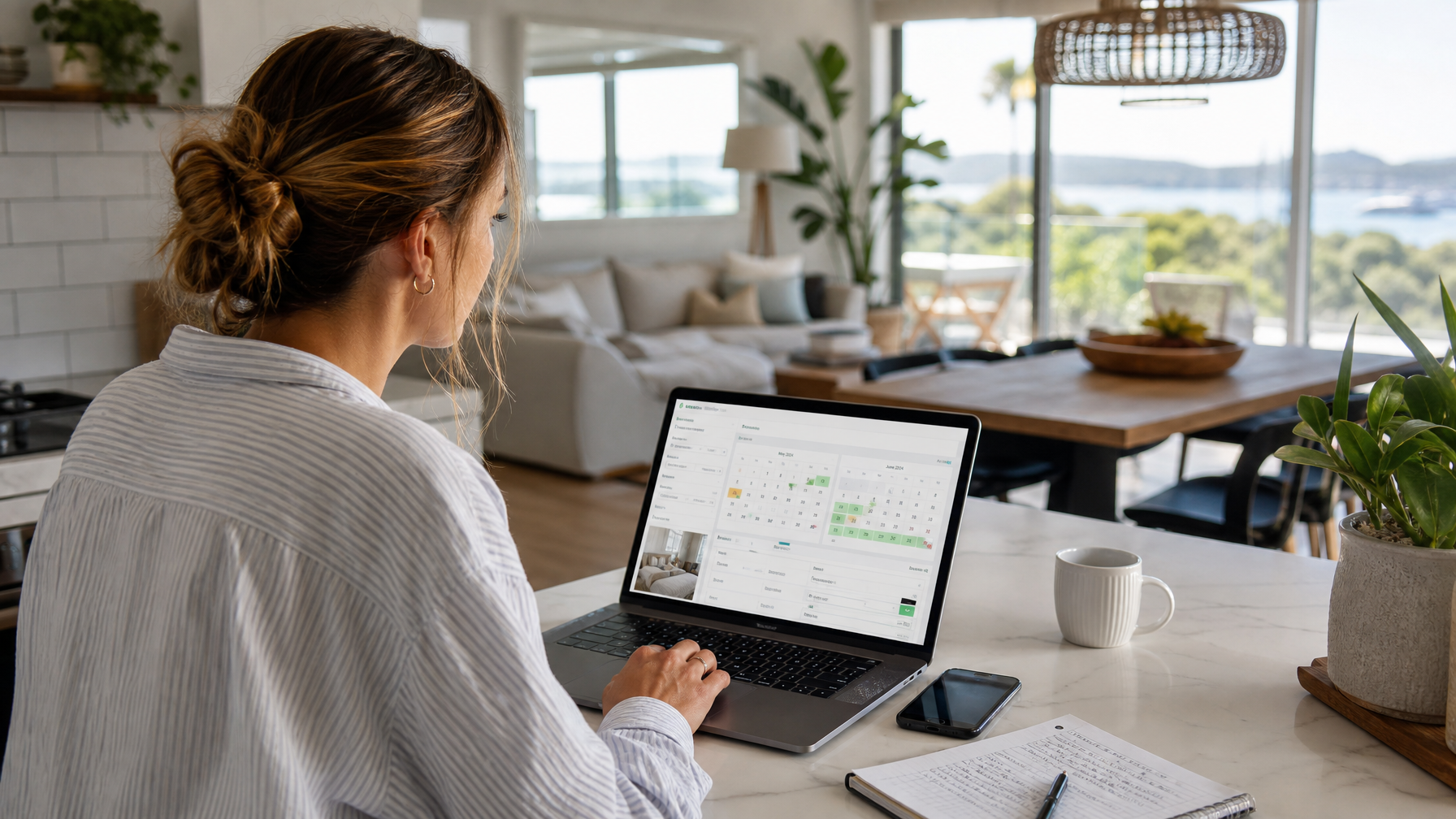 Host reviewing World Cup 2026 vacation rental pricing and calendar on a laptop in a bright open-plan kitchen