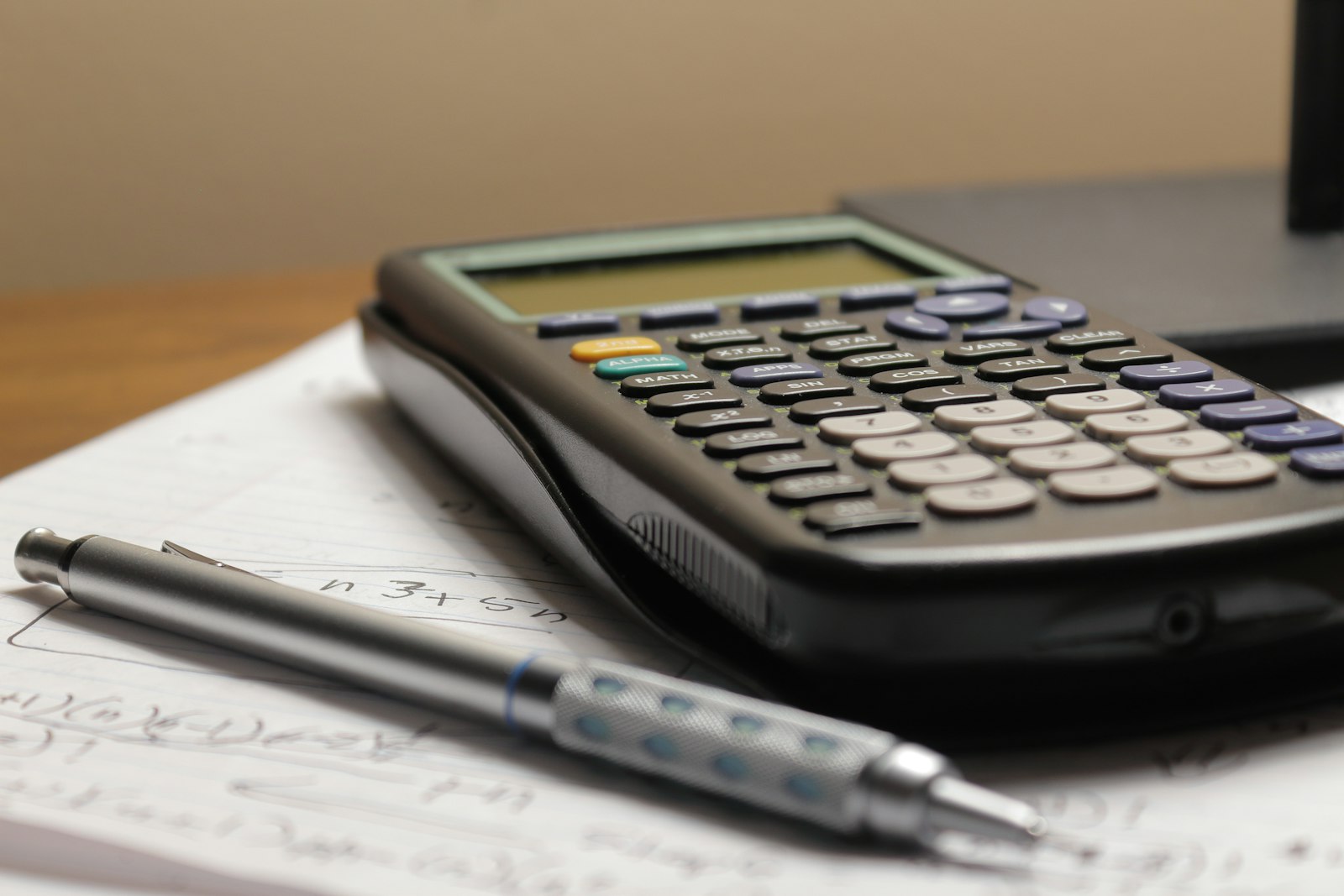 Calculator and pen resting on a sheet of figures while a host recalculates nightly rates
