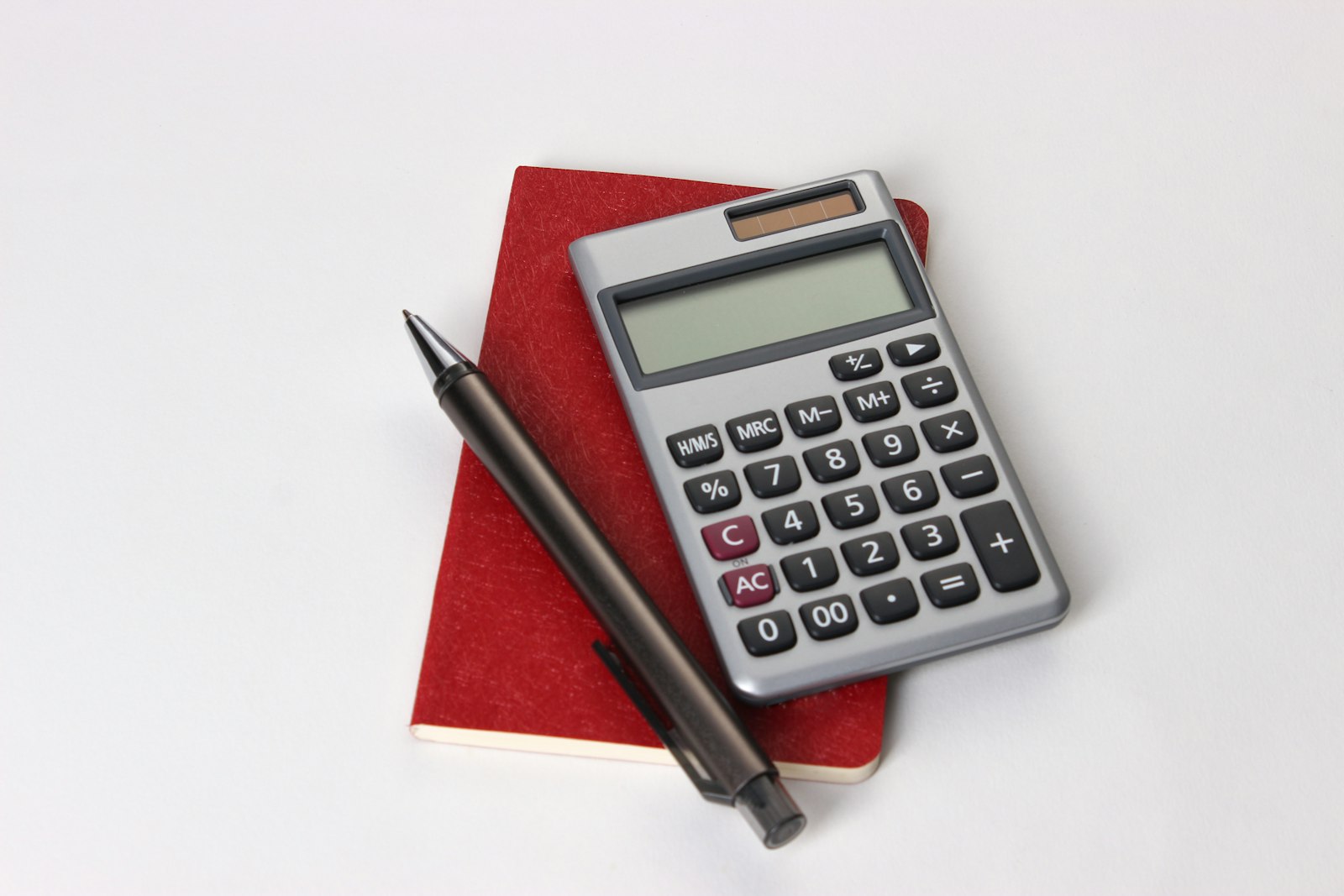 Calculator, pen and accounts on a desk where a host works through the booking subtotal
