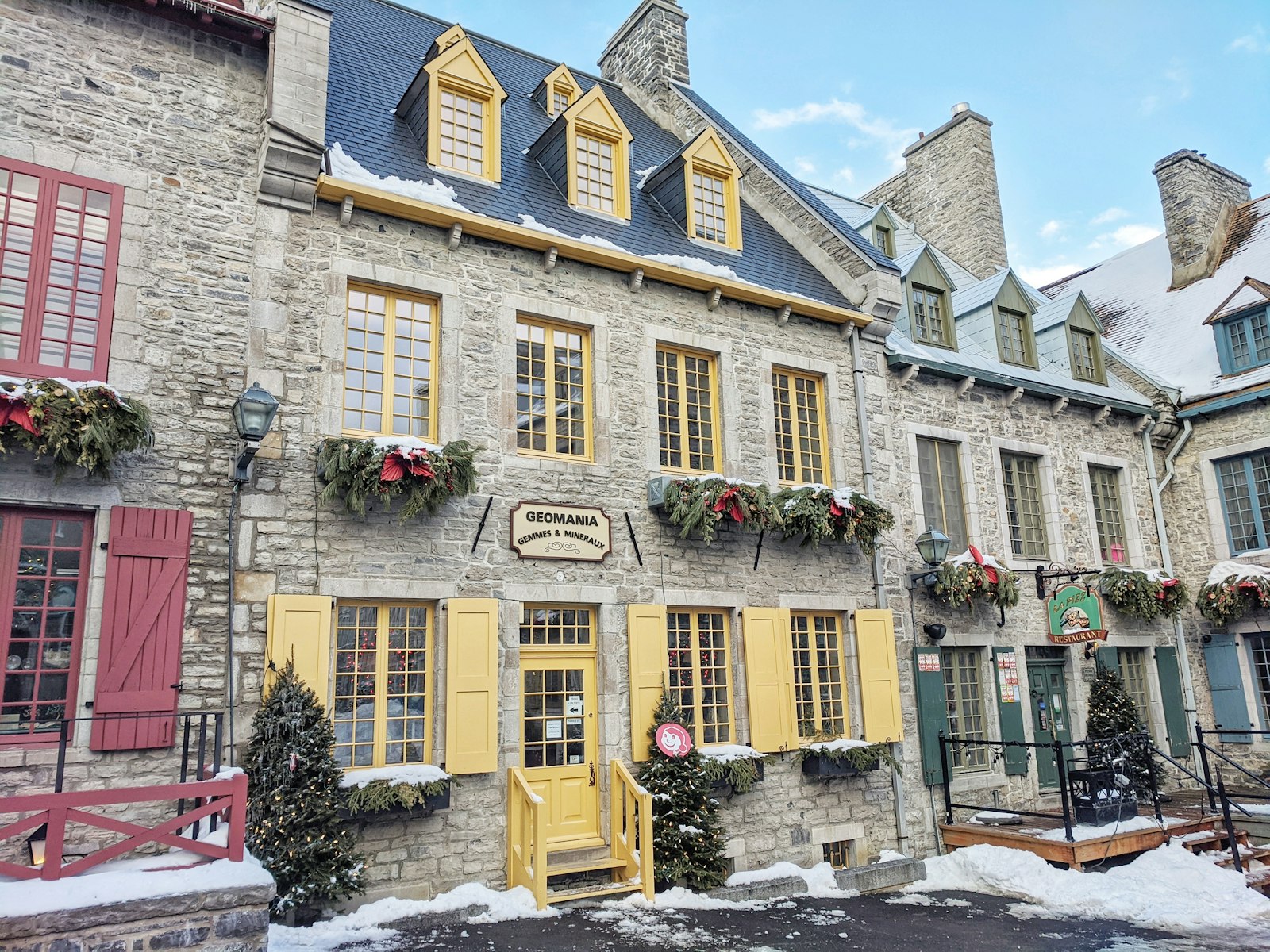 Stone building with window boxes of greenery on a street in Old Quebec City.