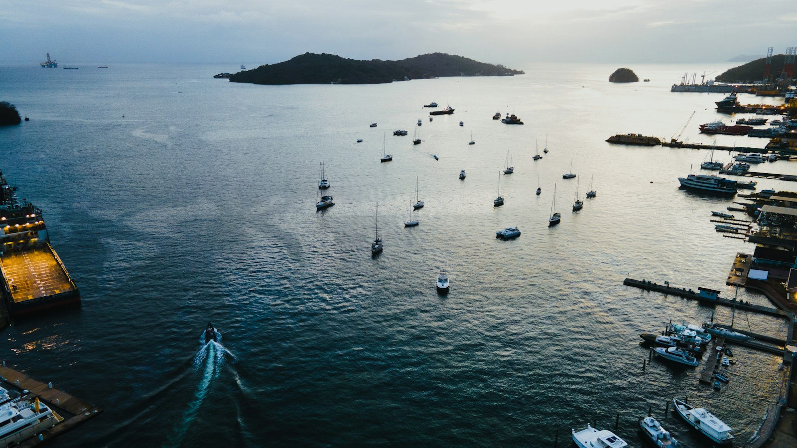 Yachts and small boats moored along pontoons in a sheltered Caribbean marina.