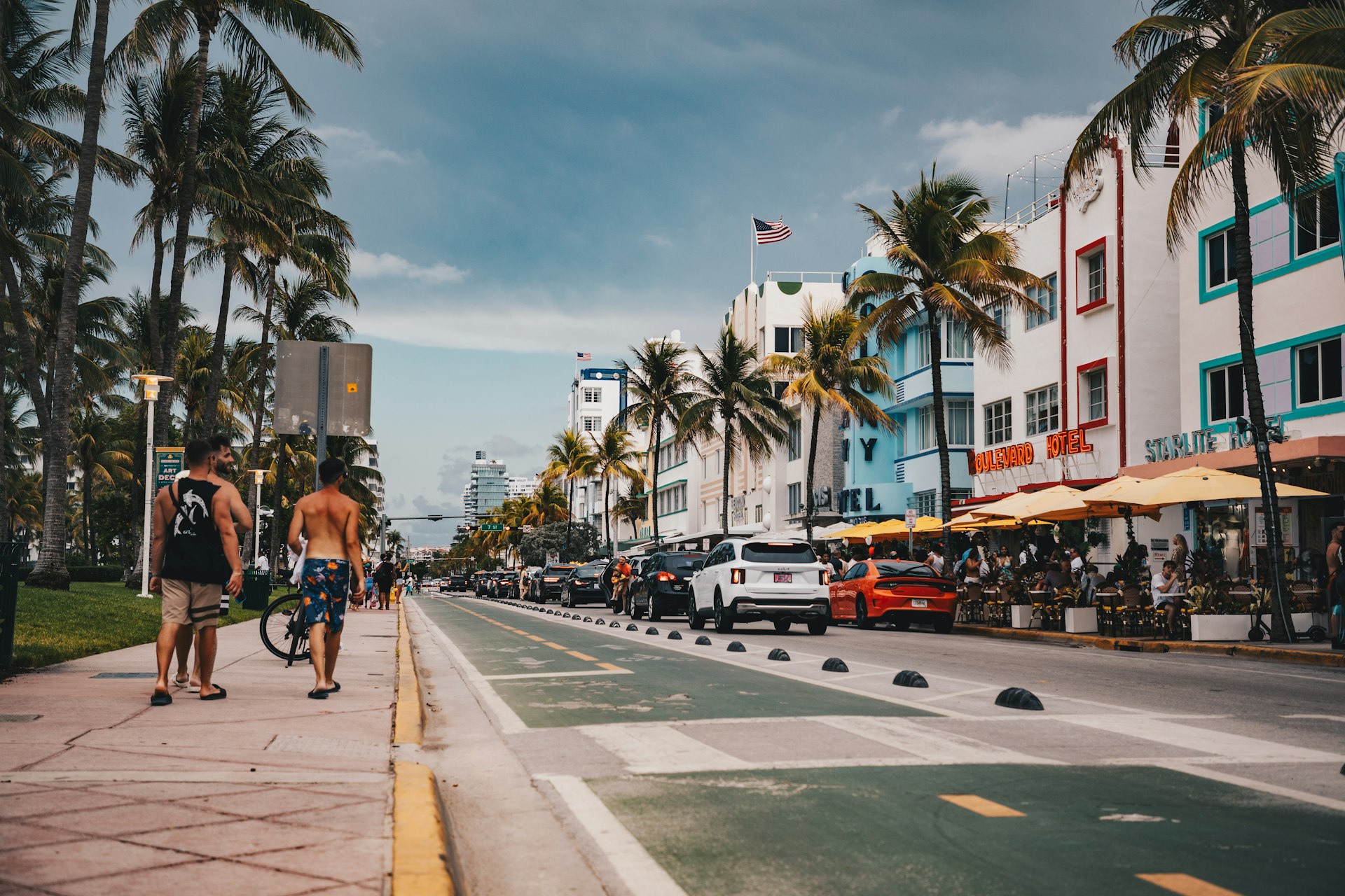 Pedestrians and palm trees along Ocean Drive with colorful buildings