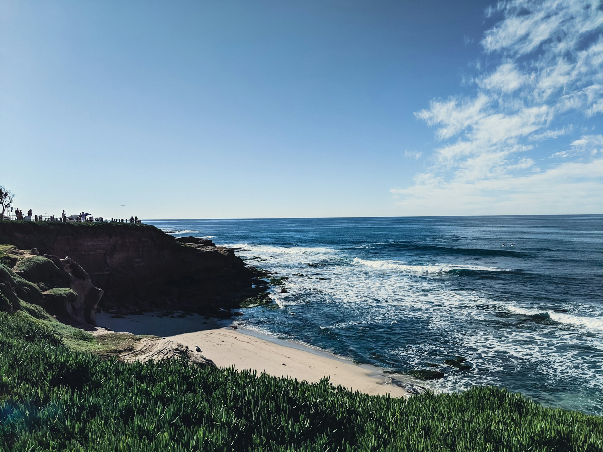 Waves breaking against rocky cliffs at La Jolla Cove with blue ocean beyond