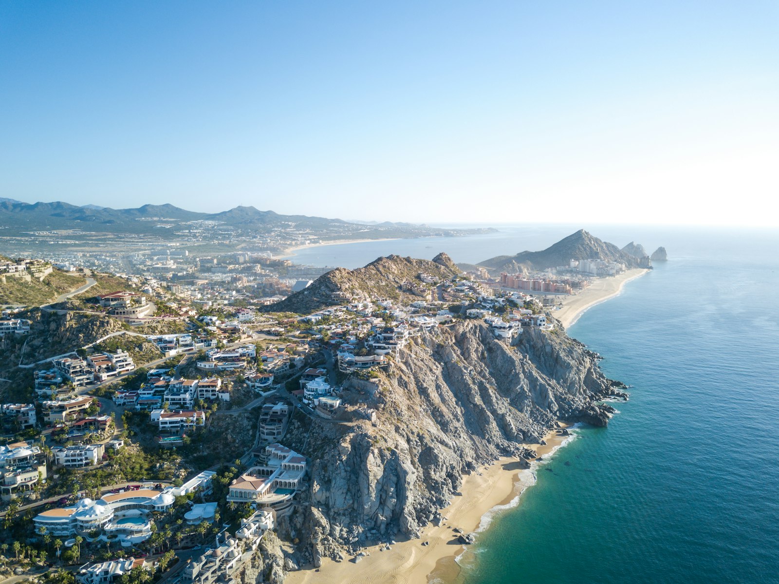 Hillside residential buildings and desert slopes above the Cabo coast