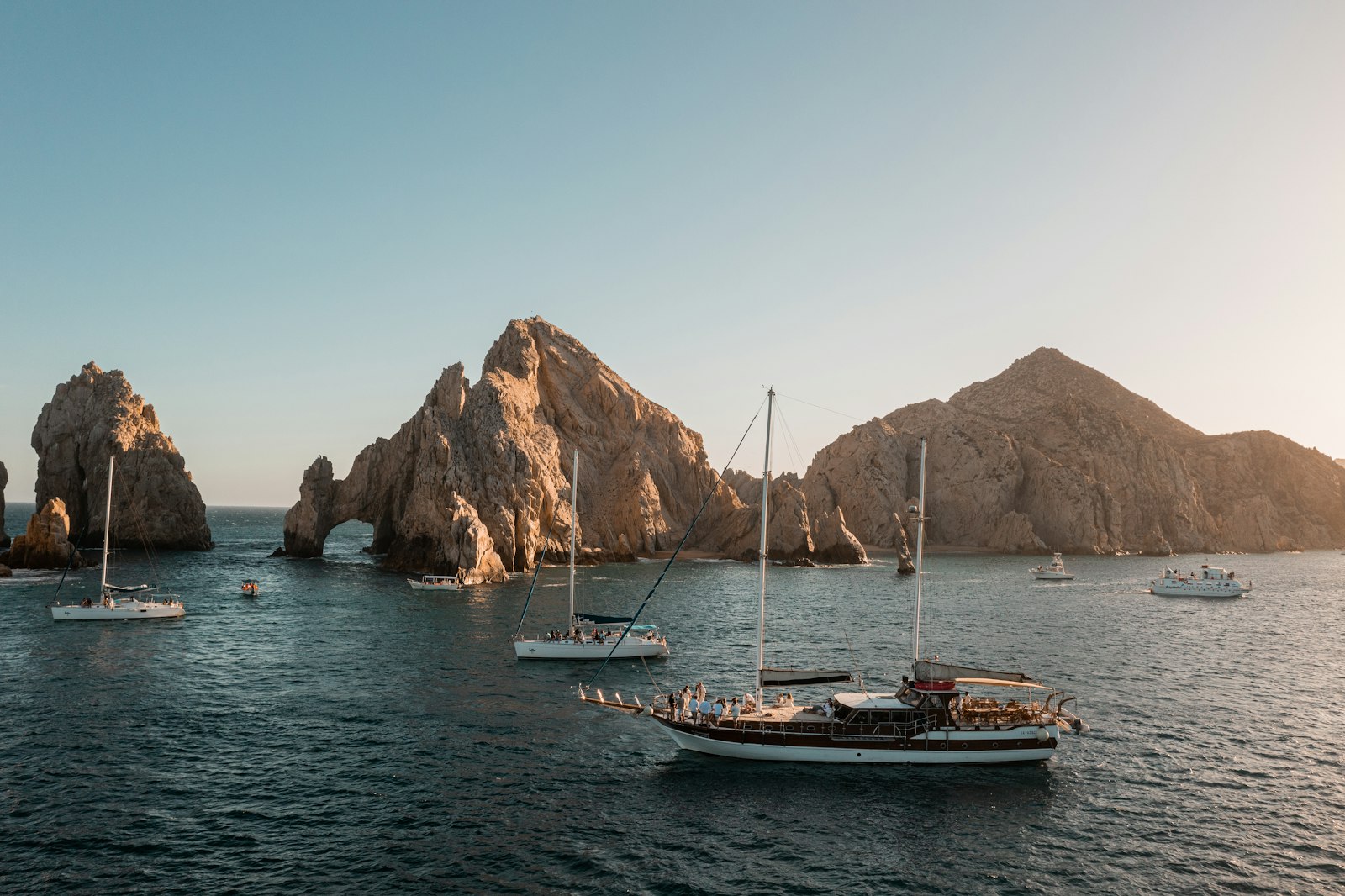 Sailboats near rocky Land's End formations on a clear day