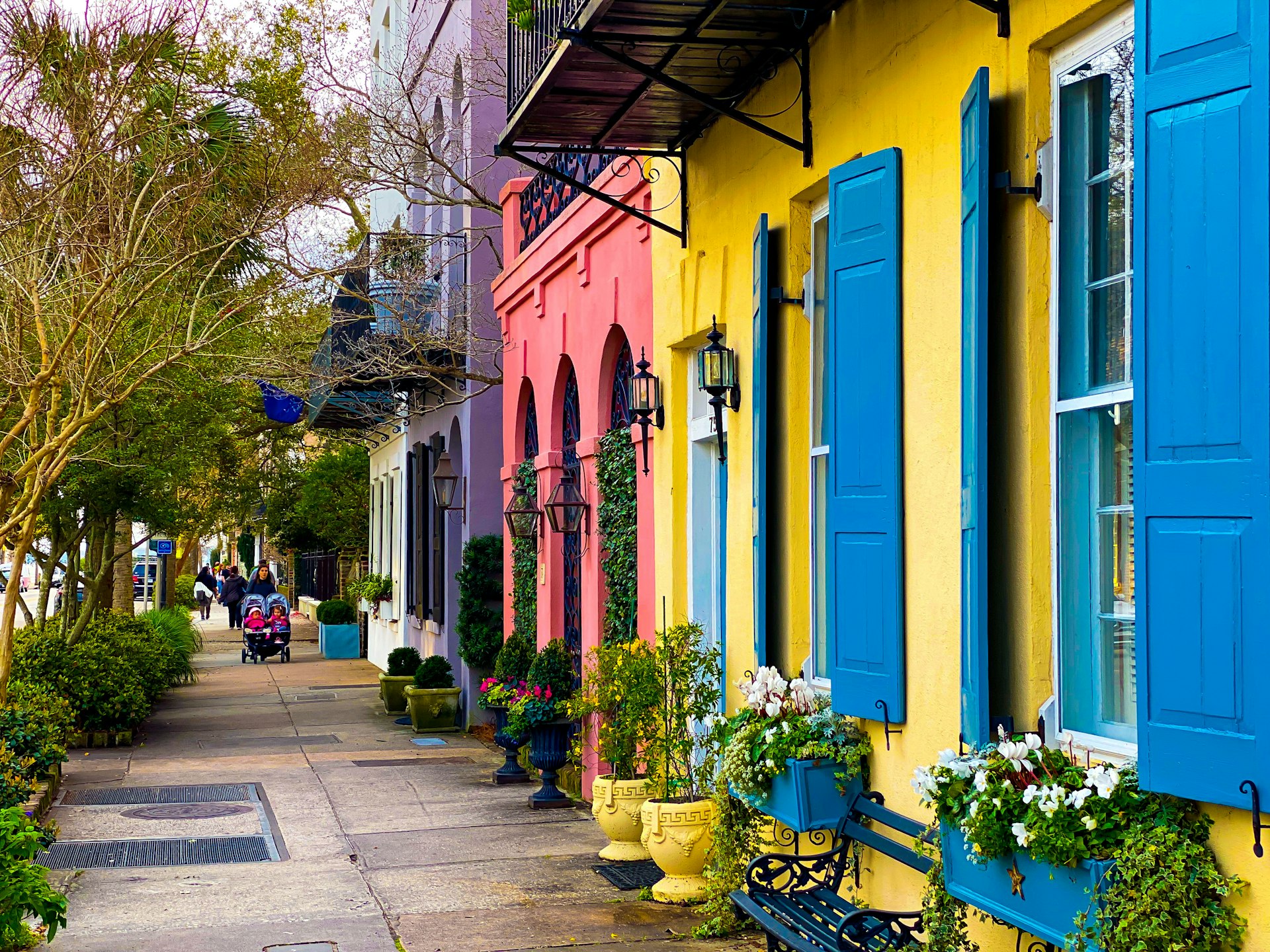 Yellow and blue Charleston house facades with shuttered windows in daylight