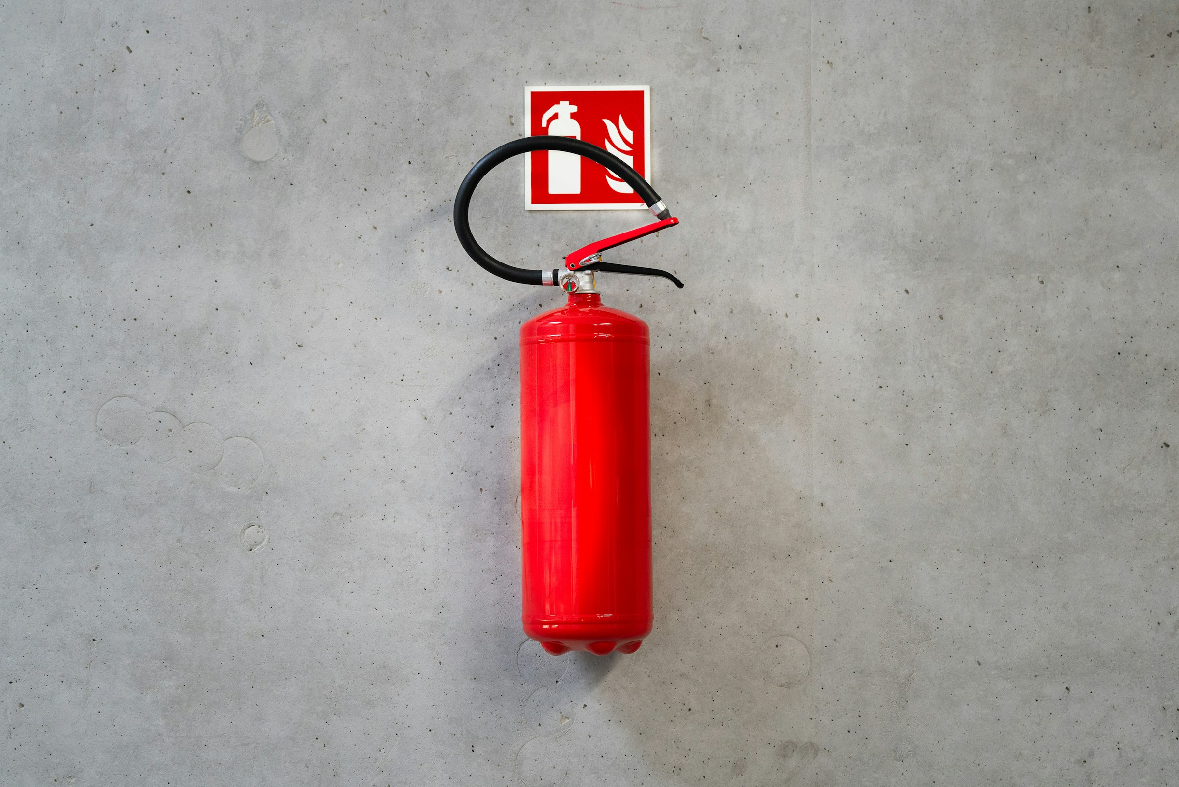 A red fire extinguisher mounted on a wall