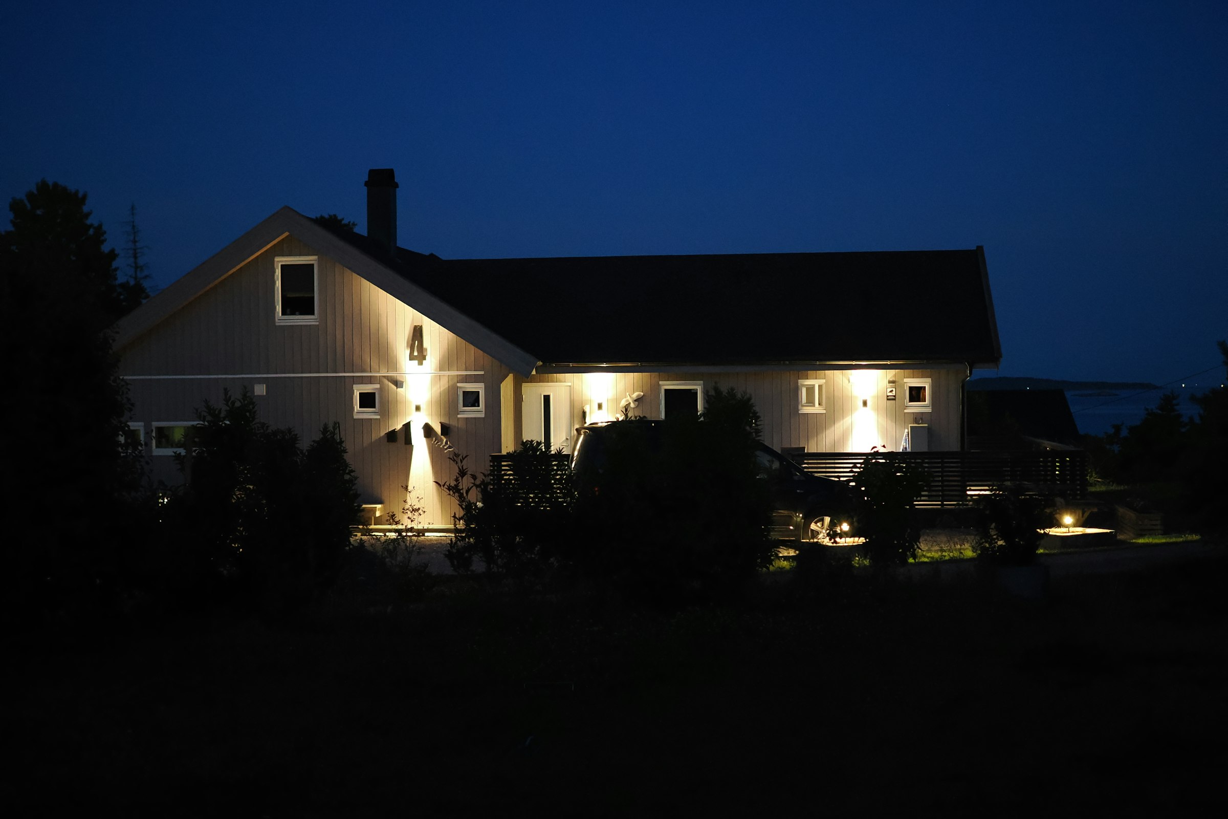 A house lit by exterior lights after dark
