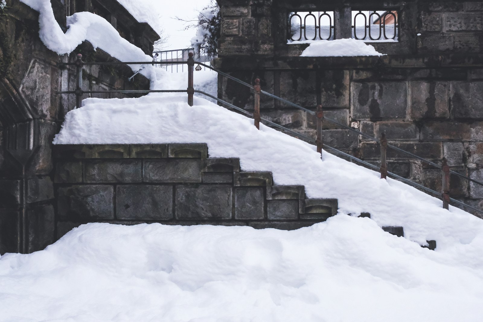 Snow-covered exterior stairs leading up to a house