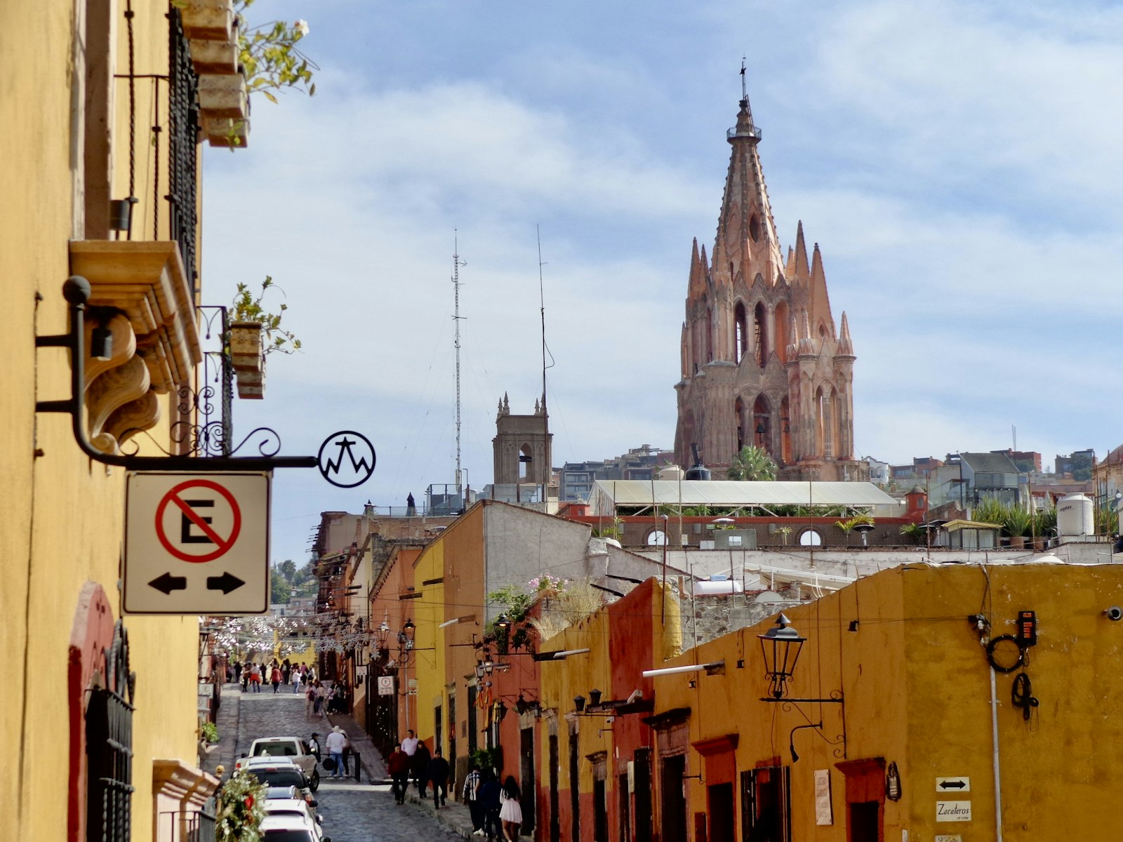 Colorful colonial buildings lining a street with a church spire in Mexico City