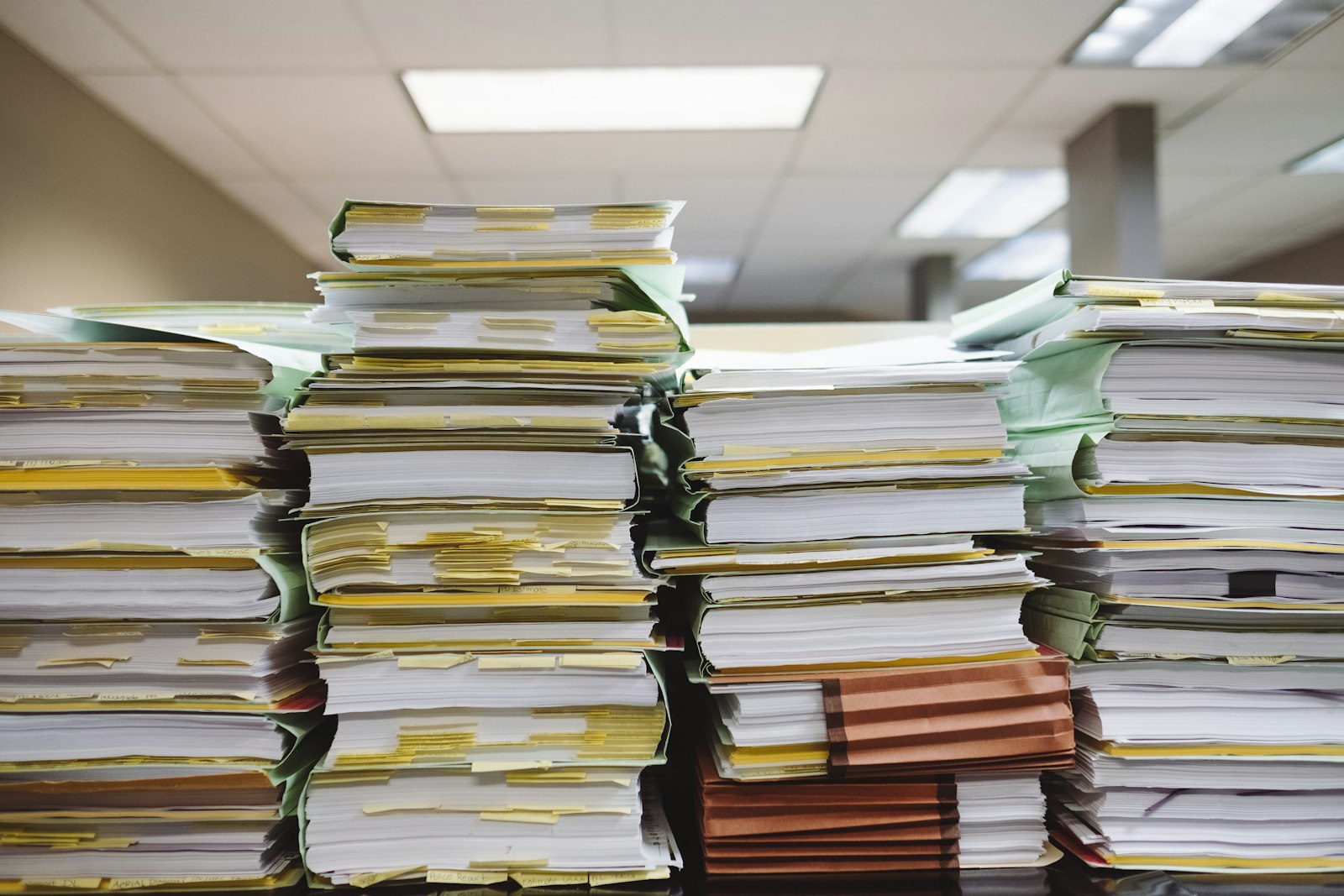 Stacks of paper documents and manila file folders