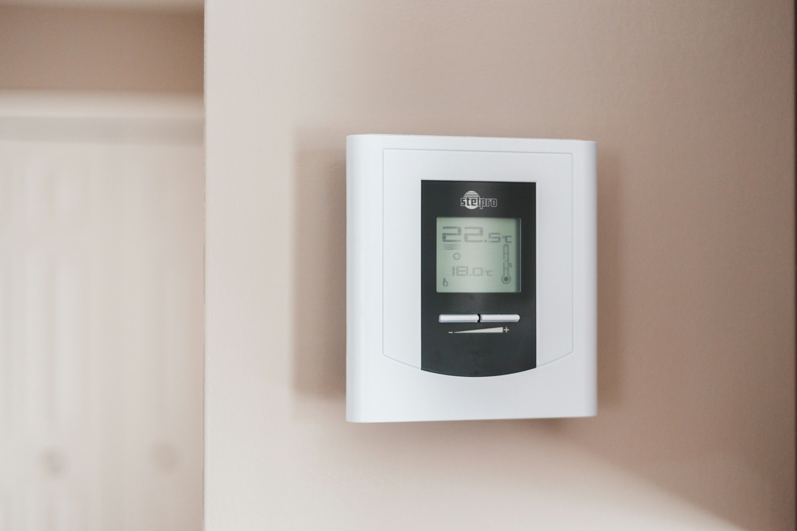 White and gray wall thermostat display in a home hallway