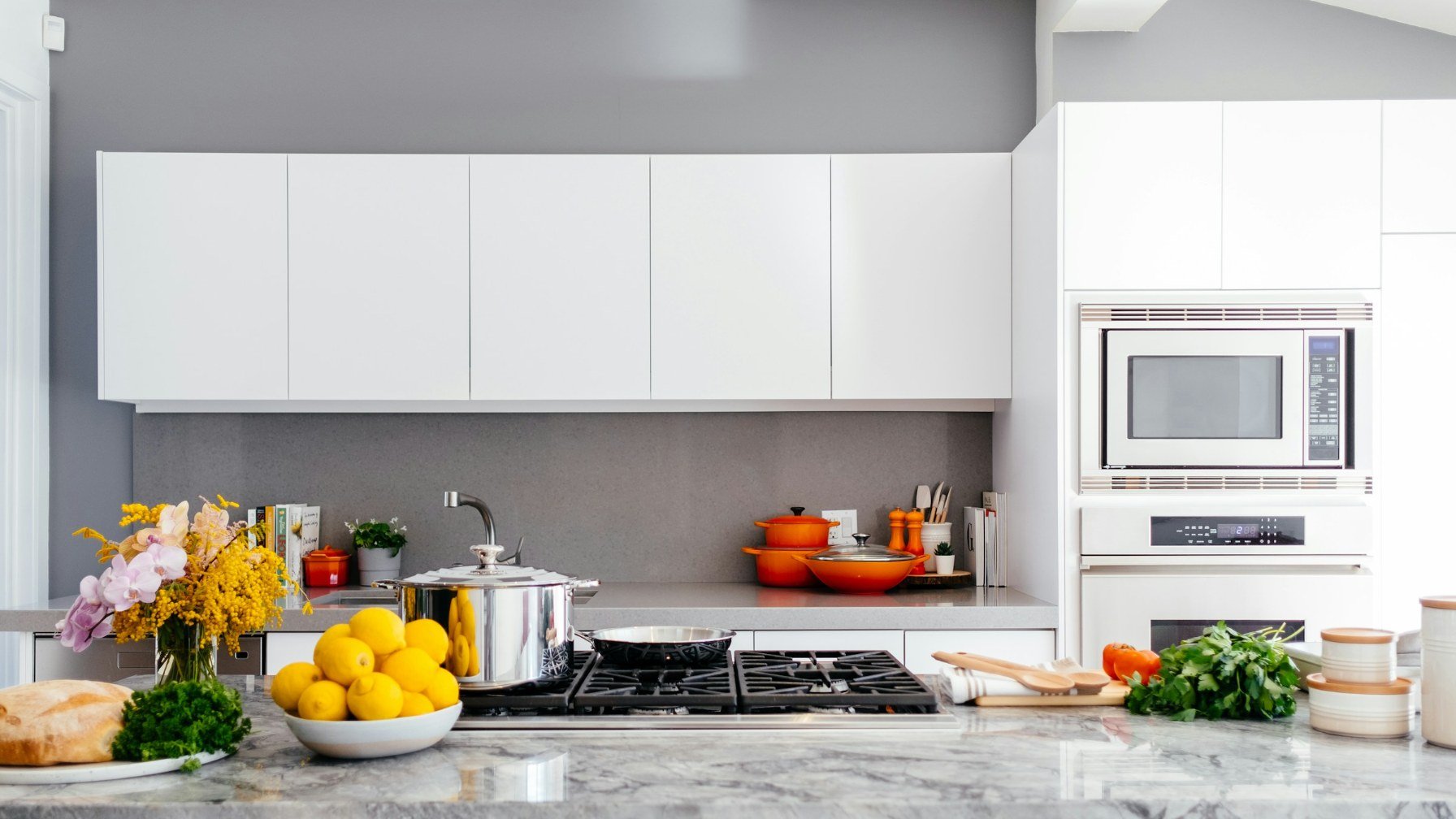 A bright white kitchen with a clear marble island and empty worktops