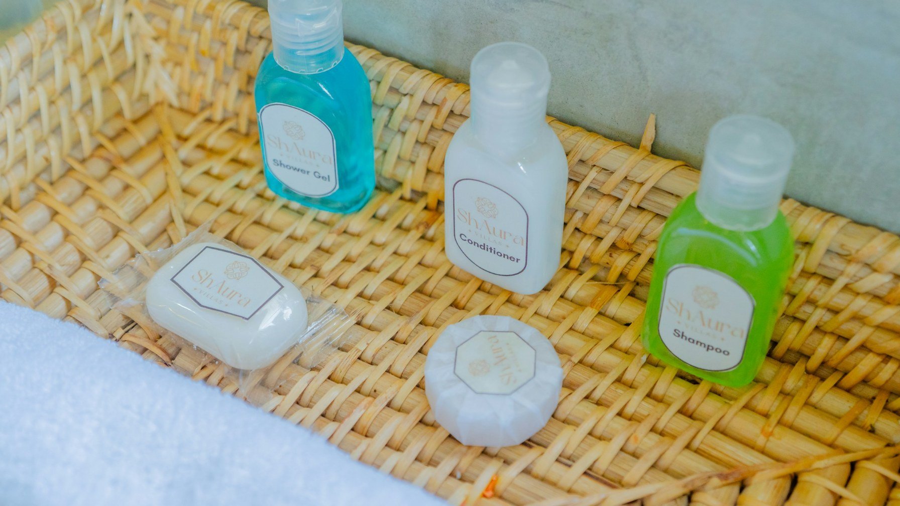 Soap and small toiletry bottles arranged in a woven basket on a bathroom counter