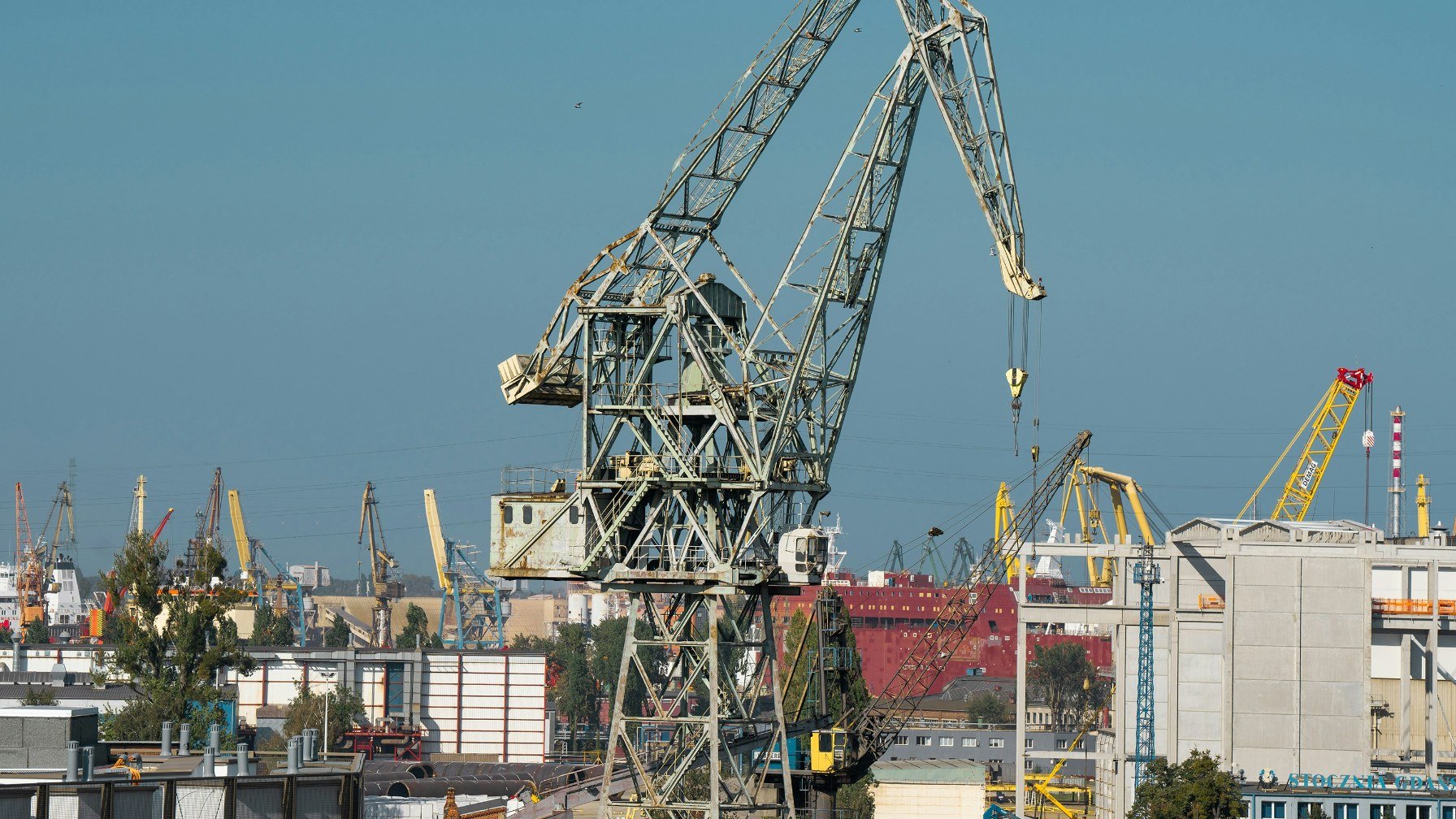 The tall cranes of the historic Gdansk Shipyard standing against the sky