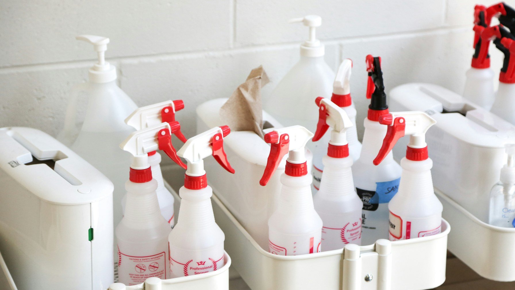 A tray of plain unlabelled spray bottles on a clean counter