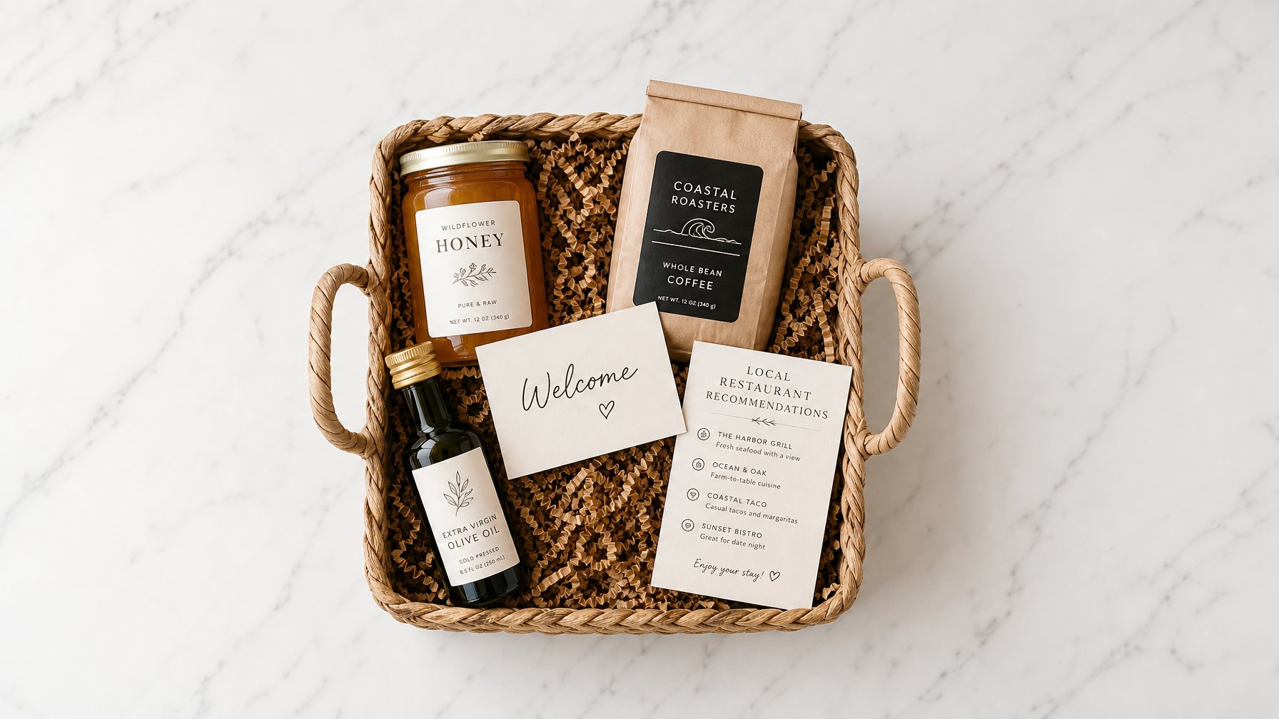 Overhead flat-lay of a vacation rental welcome basket with local honey, artisan coffee beans, a handwritten welcome card, and a printed restaurant recommendation list