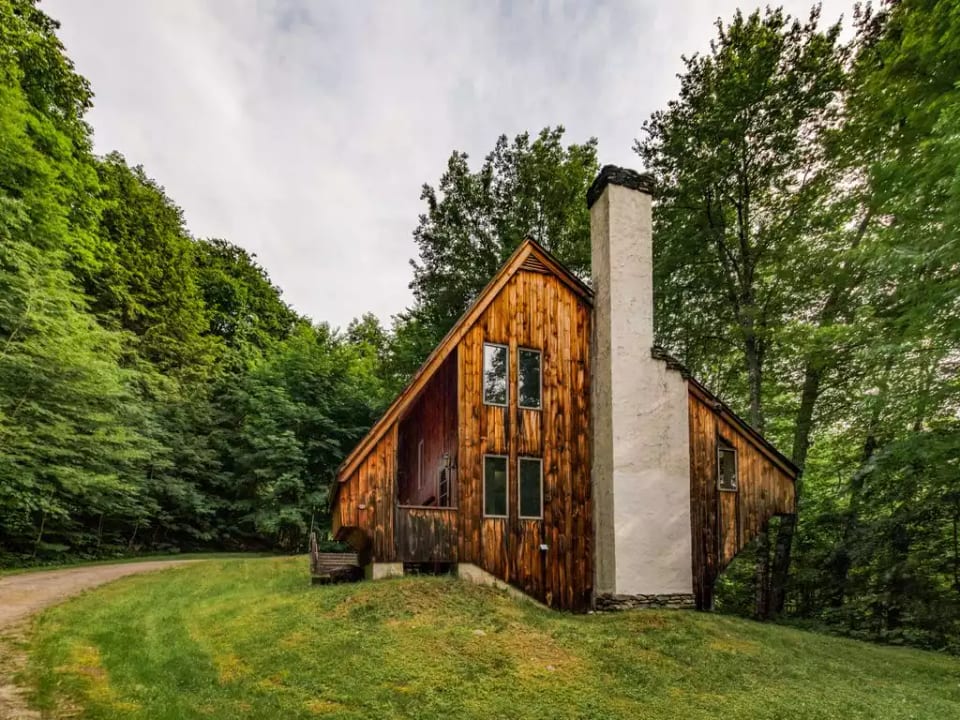 View of the house from the driveway.  On over an acre, surrounded by trees.
