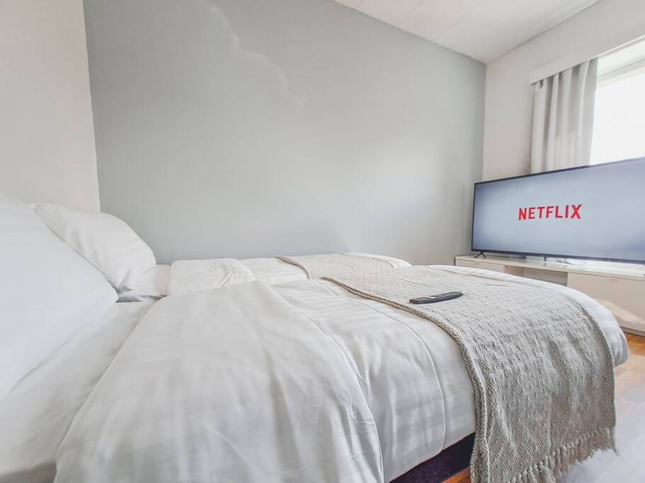 You can watch the huge 4k Smart TV while laying comfortably in full satin bedding.