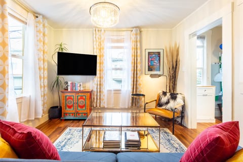 Enjoy your favorite shows and a splash of color in our vibrant living room, where entertainment meets lively decor.