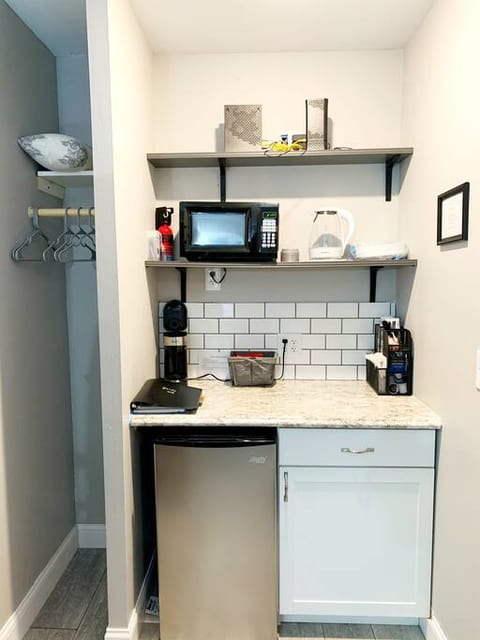 Kitchenette with microwave, mini fridge, coffee station, hot water kettle.