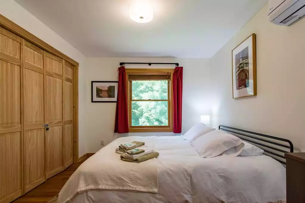 This king bedroom on the main floor dons views of the forest and has a mini-split ductless heat/AC unit. This king bedroom on the main floor dons views of the forest and has a mini-split ductless heat/AC unit. - MOUNTAIN SKI CHALET | INCREDIBLE CATSKILLS VIEWS - Prattsville