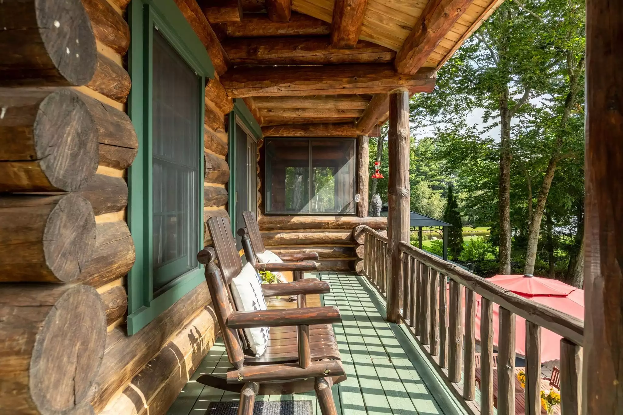 Rocking chairs on the deck overlooking Baxter Lake  - Kane Cabin Log Home w/beach on Baxter Lake, NH - Farmington