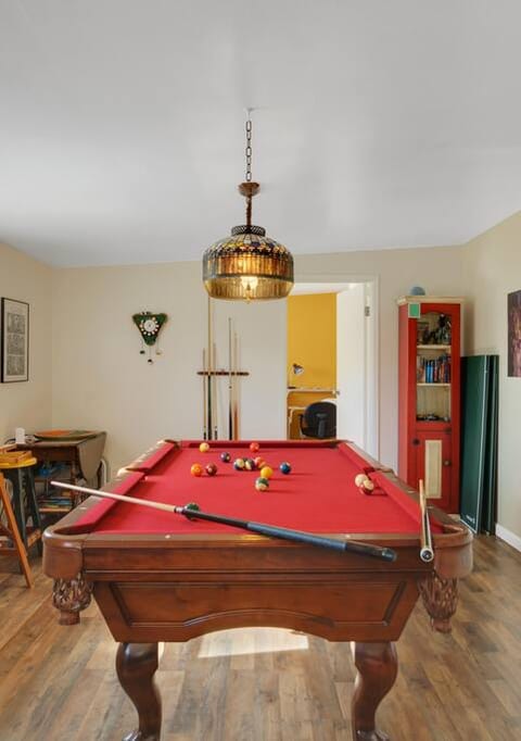 A bar-sized pool table, just waiting to be enjoyed. Also included is a ping-pong table overlay, a bumper pool table, a poker table, and board games galore.