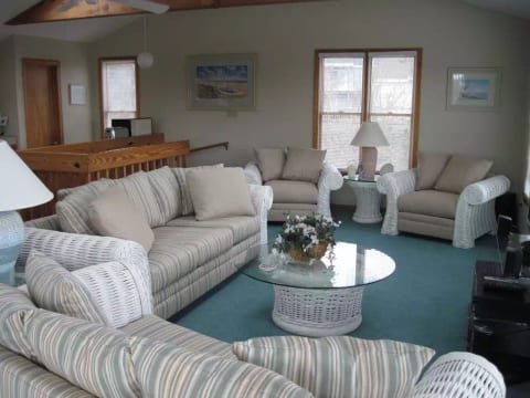 Great Room with cathedral ceiling, ceiling fan, skylights, sliding door to deck