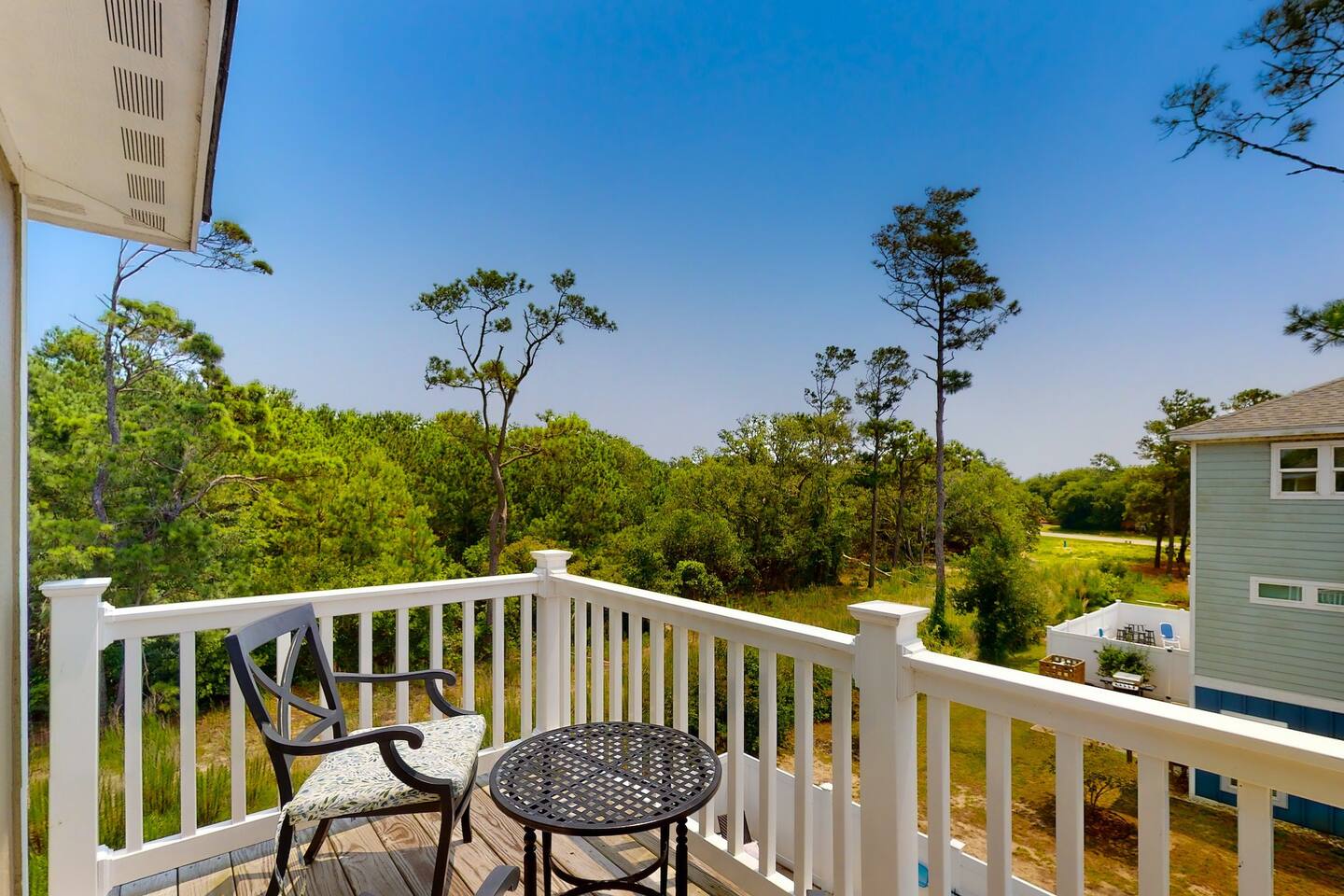 Step into nature's embrace through the wood terrace, just beyond the elegant dining area's glass door."
