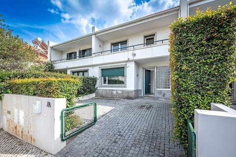 Exterior Charm: Inviting entrance flanked by lush greenery, perfect for enjoying Lisbon’s sunshine!