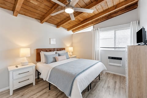 Your serene queen bedroom offers plush bedding, ample storage, and a calming coastal ambiance for a perfect night’s rest.