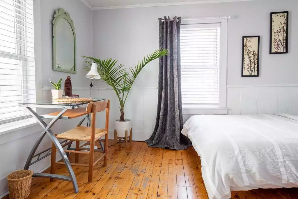 Desk with books and decor, reading light, large mirror and plants. - Bohemian Penthouse | 1min Walk Restaurants + Shops - Winooski