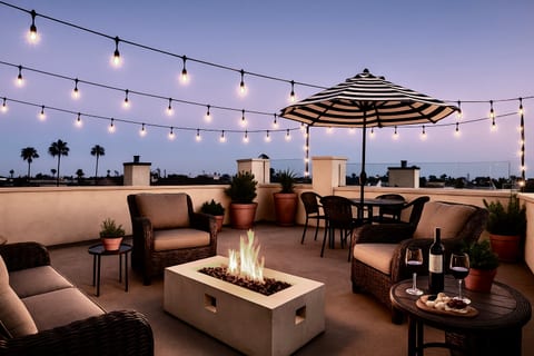 Roof deck amenities include a grill, dining area, fire pit, and cozy lounge furniture – perfect for evening relaxation.