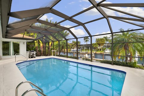 Screened and heated pool with canal view.