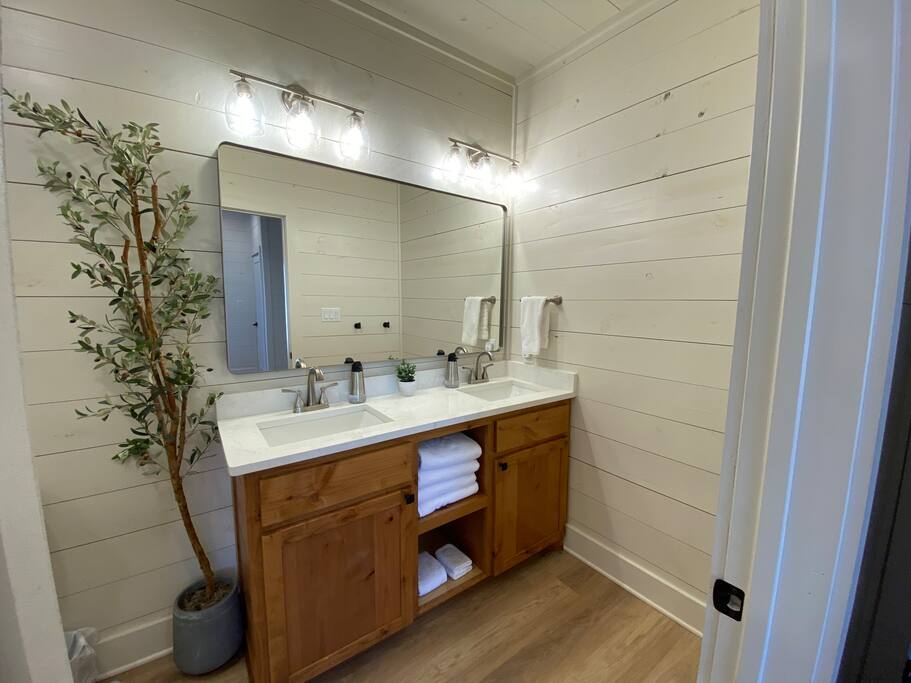 Modern bathroom with double vanity, large mirror, and stylish lighting.