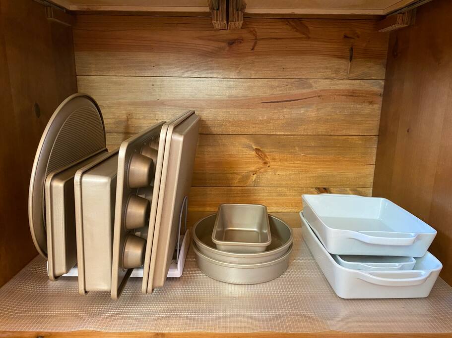 Organized wooden kitchen cabinet with neatly stacked dishes.