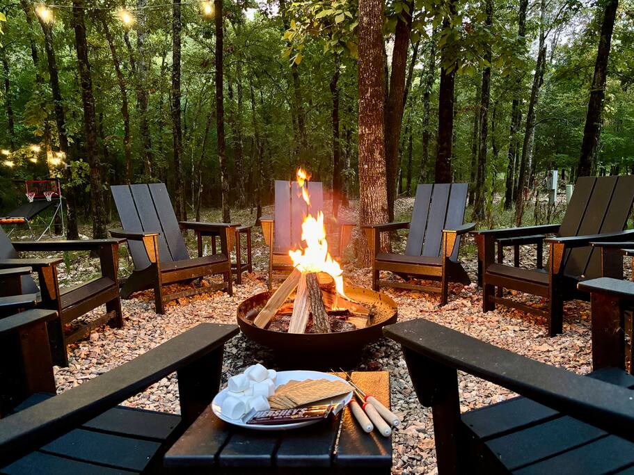 Cozy outdoor fire pit with Adirondack chairs in the forest of Broken Bow.