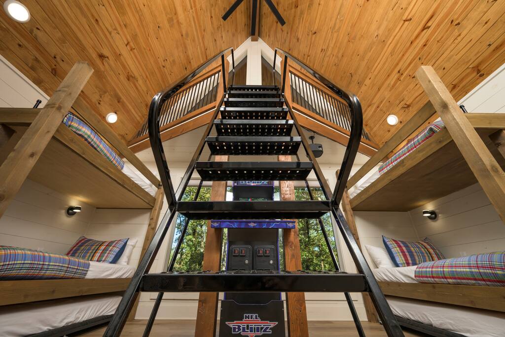 Inviting cabin vibes with rustic bunk beds, loft charm, and scenic window views.