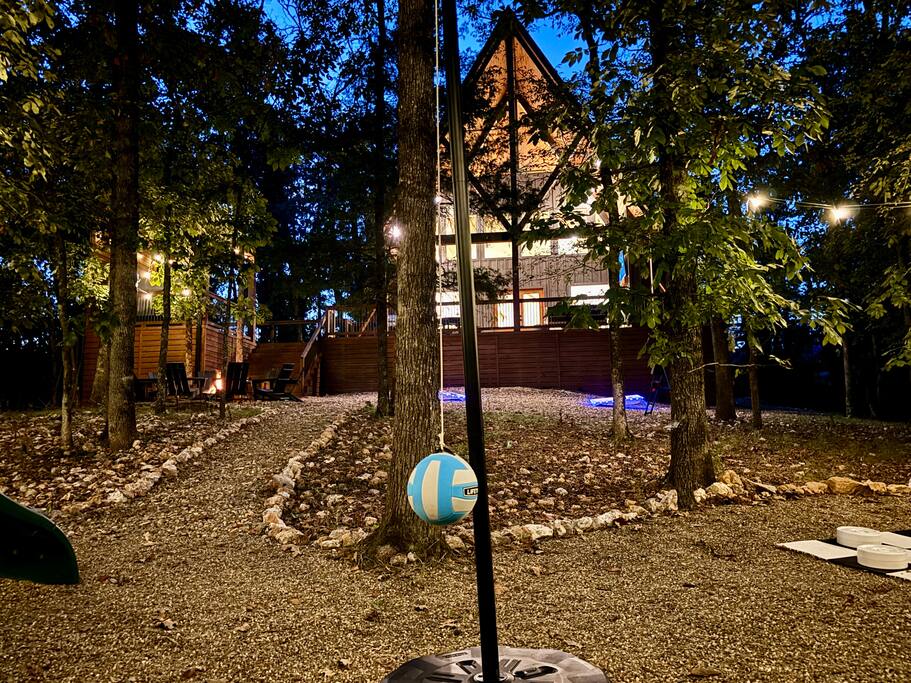 Cabin retreat with outdoor games under twinkling lights in the forest.