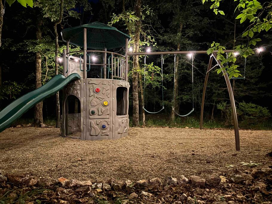 Enchanting nighttime playground with slide and swings in the forest of Broken Bow.