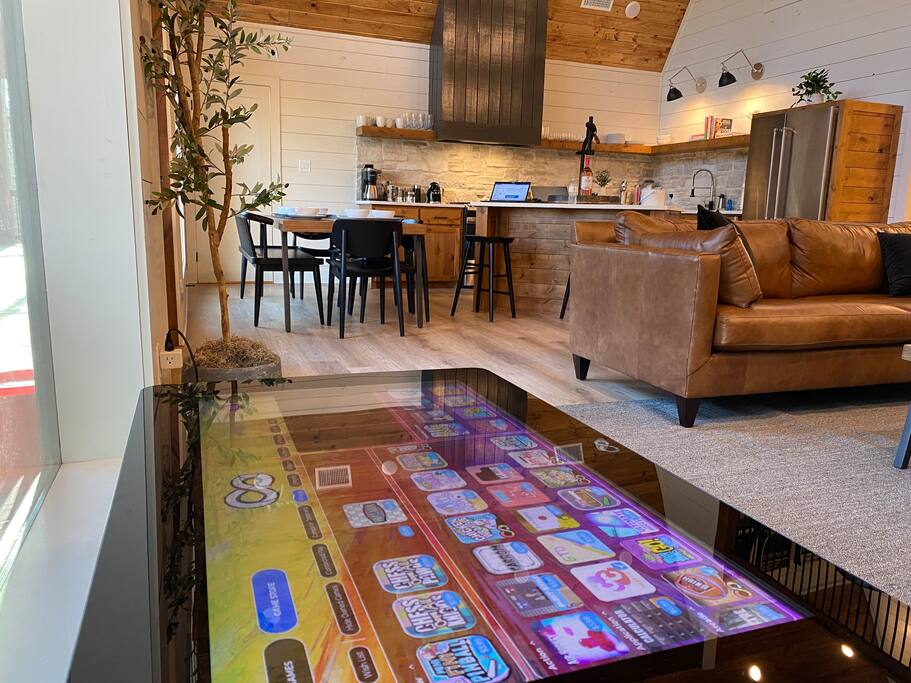 Cozy modern kitchen and living area with interactive gaming table.