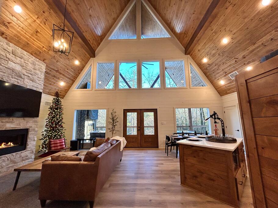 Cozy cabin living room with a stone fireplace, modern decor, and warm ambiance.