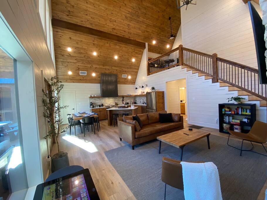 Cozy cabin living room with high ceilings, warm wood accents, and a fireplace!