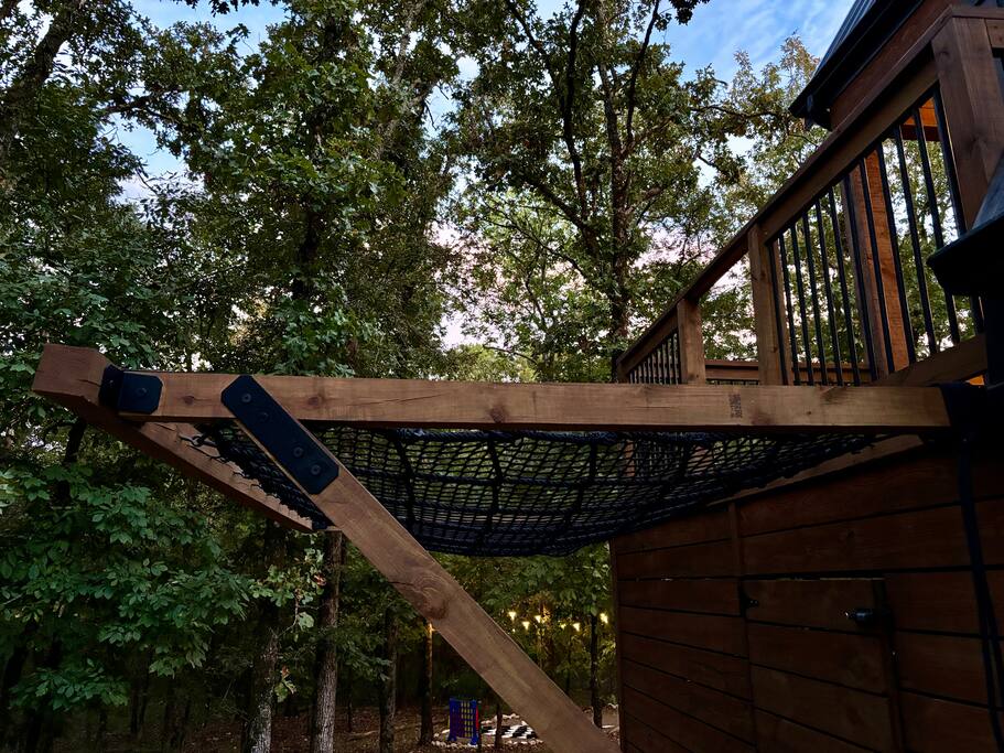 Elevated wooden deck with a hammock, perfect for relaxing in nature.