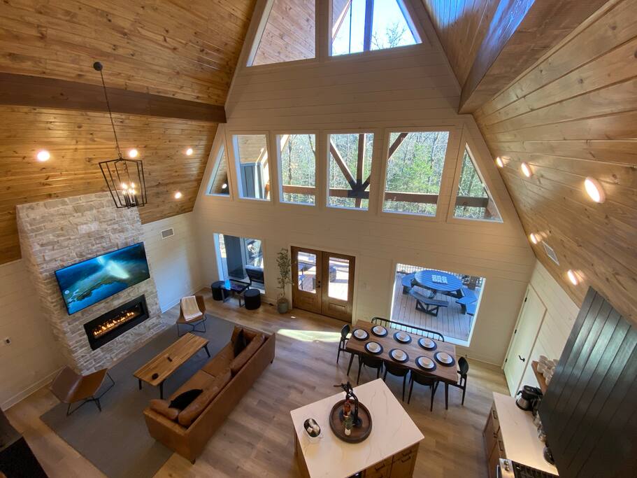 Rustic-modern cabin with cozy fireplace, vaulted ceilings, and elegant dining area.